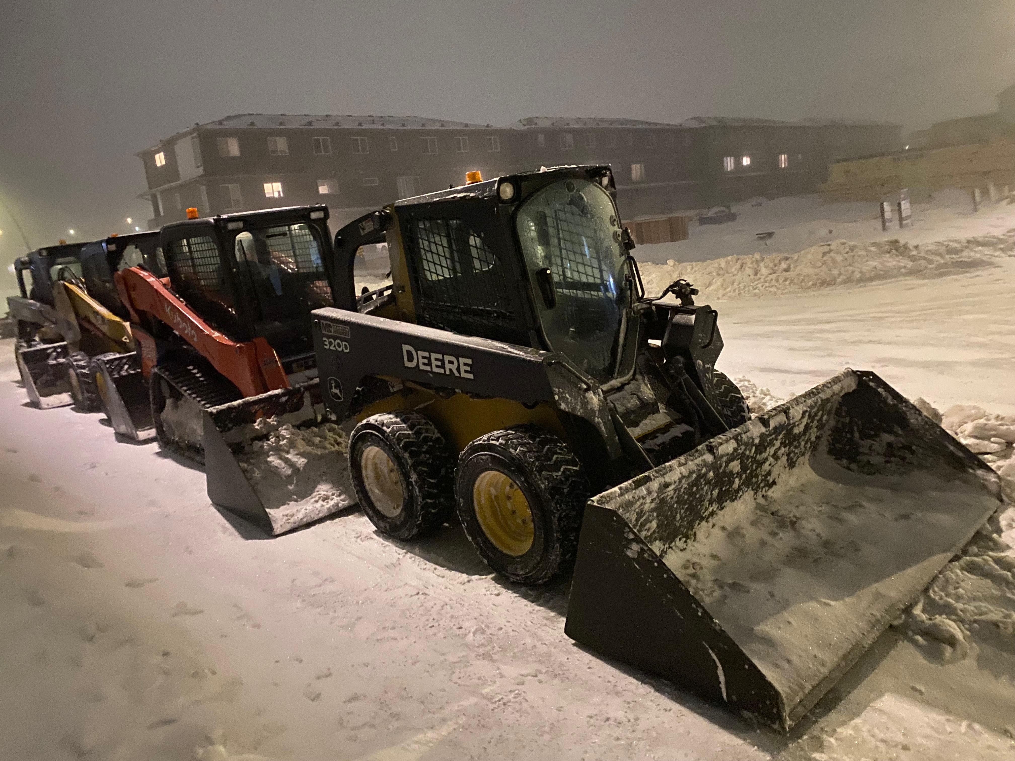 Close-up of John Deere skid steer with plow blade at night